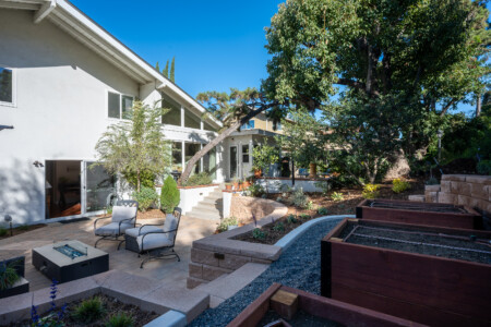 Private backyard patio with lounge seating and peaceful greenery, creating a relaxing outdoor extension of the home. A great space to unwind, work outside, or enjoy slow mornings during longer stays.