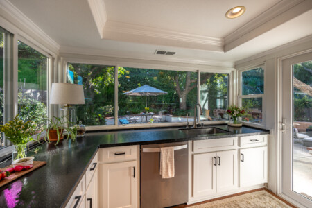 Kitchen with expansive windows offering beautiful backyard views and abundant natural light. A bright, uplifting space that makes everyday cooking and cleanup more enjoyable.