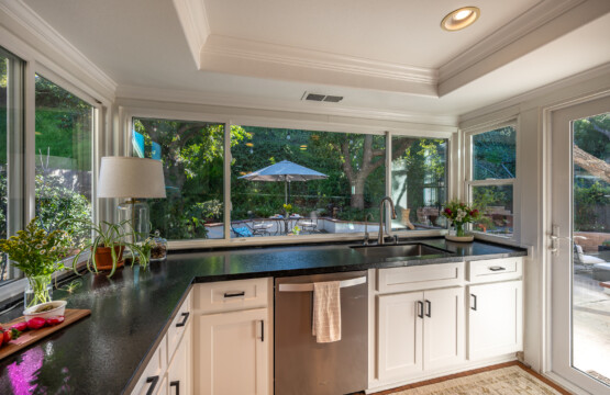 Kitchen with expansive windows offering beautiful backyard views and abundant natural light. A bright, uplifting space that makes everyday cooking and cleanup more enjoyable.