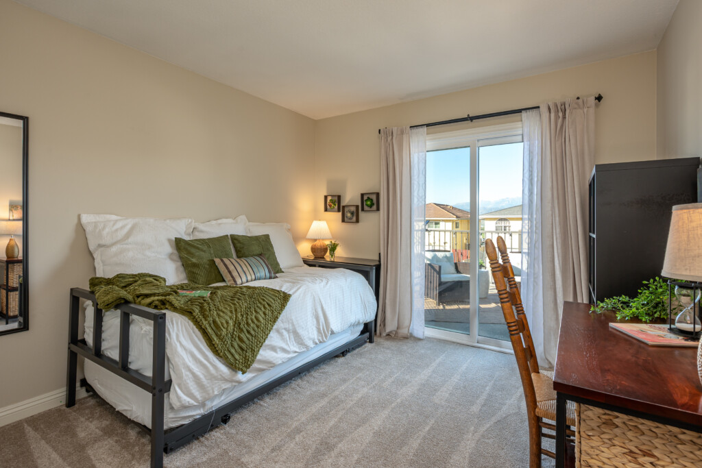 Bright, comfortable bedroom with balcony access and flexible space for rest or light work. A peaceful spot to enjoy natural light, fresh air, and quiet downtime.