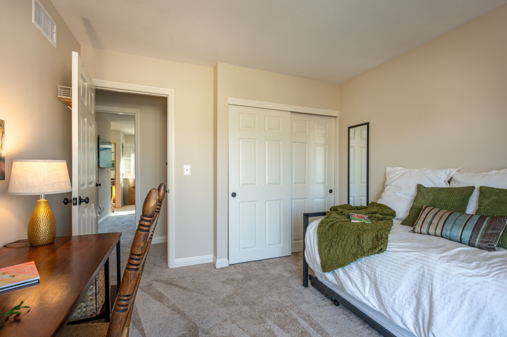 Airy bedroom with balcony access, natural light, and a dedicated desk plus storage for everyday organization. A comfortable setup that supports both focused work time and restful downtime.