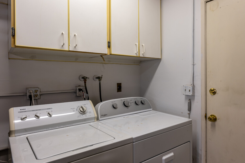 Laundry area with washer, dryer, and overhead storage cabinets for everyday convenience.