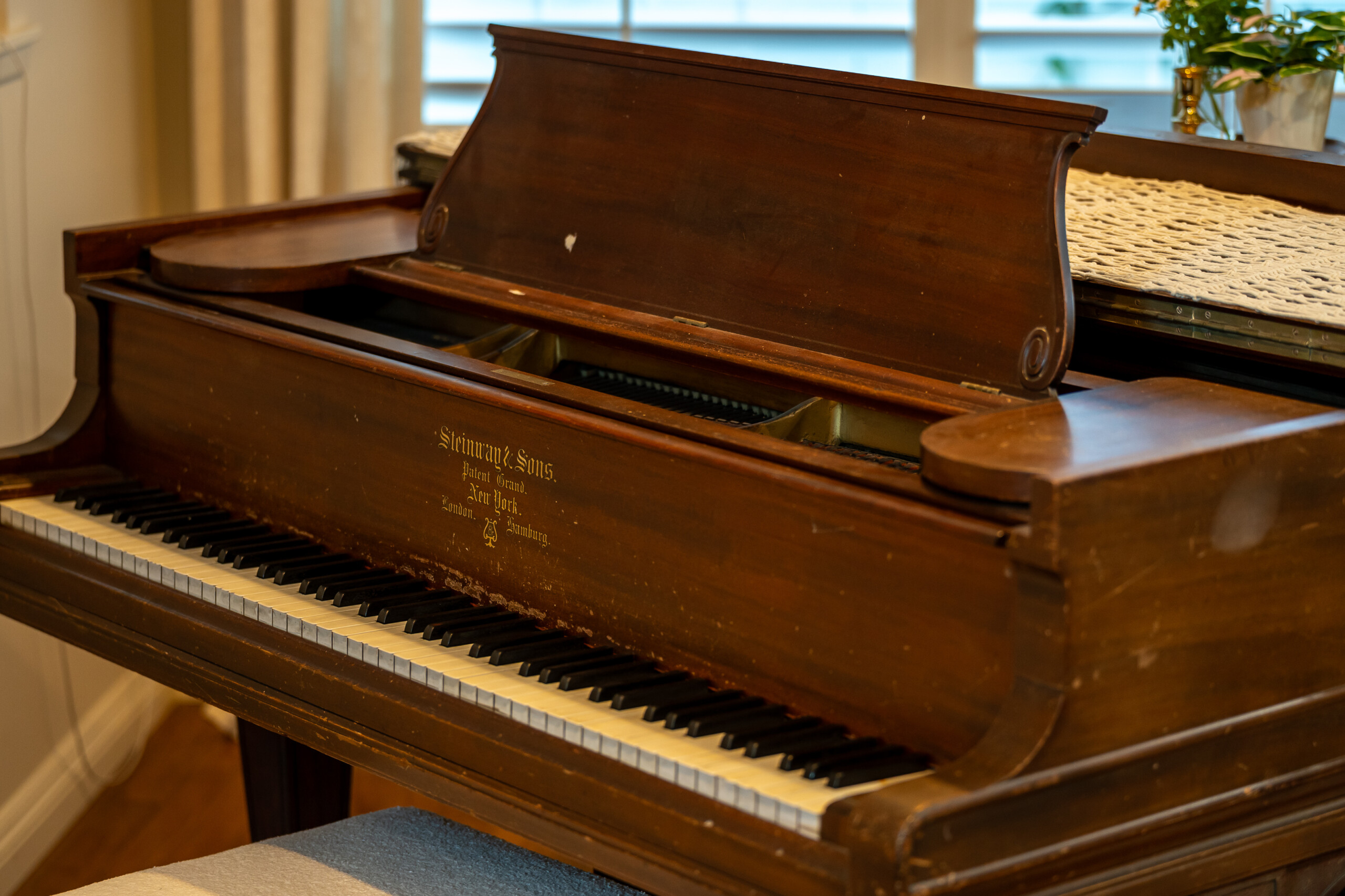 Classic wooden piano adding warmth and character to the space with a timeless, elegant feel.