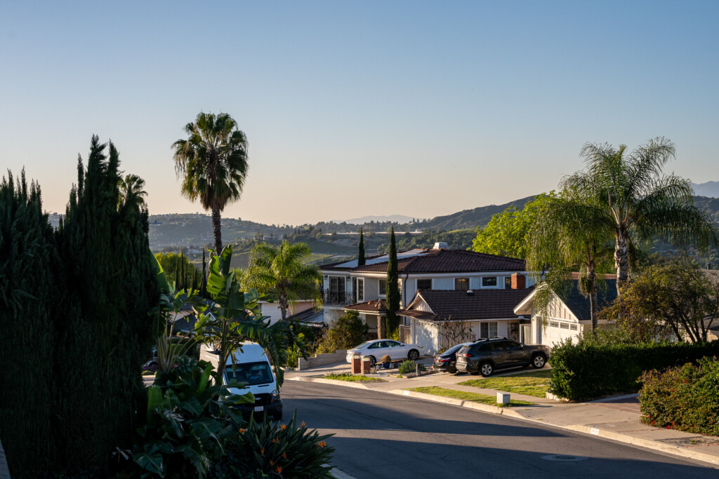 Peaceful neighborhood setting surrounded by greenery, palm trees, and scenic hillside views — offering a calm, relaxing atmosphere while still being close to everyday conveniences.