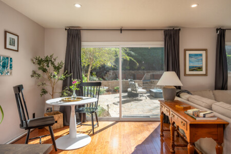 Bright, comfortable living area with natural light, lounge seating, and a cozy nook perfect for morning coffee or laptop time. A versatile space designed for both relaxation and everyday living.