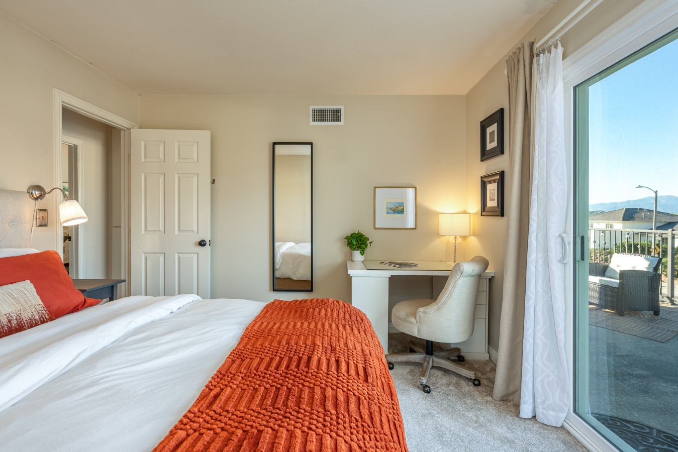 Bright, comfortable bedroom with a dedicated workspace and direct access to a private balcony. A great setup for guests who want fresh air, natural light, and a quiet place to focus or unwind.