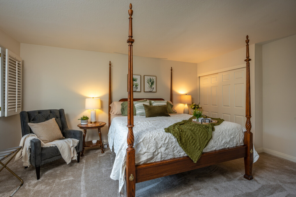 Spacious, calming bedroom featuring a statement four-poster bed and soft, layered textures for restful nights. A comfortable retreat designed to help guests fully settle in and feel at home.