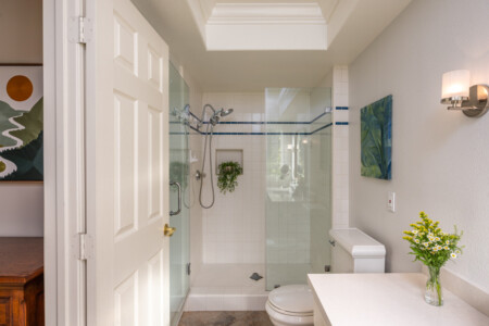 Clean, spacious bathroom with a glass walk-in shower and bright skylight for natural light. A comfortable, practical setup for extended stays and everyday routines.