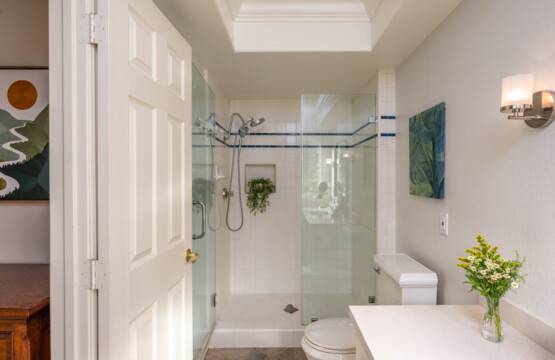 Clean, spacious bathroom with a glass walk-in shower and bright skylight for natural light. A comfortable, practical setup for extended stays and everyday routines.