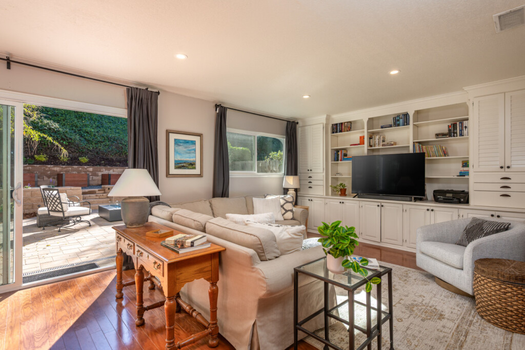 Comfortable lounge space with built-in shelving, TV, and easy access to the outdoor patio for seamless indoor-outdoor living. Perfect for relaxing evenings, movie time, or casual work-from-home days.