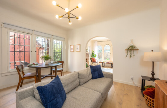 An open, light-filled living area that flows seamlessly from dining to lounge, framed by original archways. With comfortable seating and leafy views, it’s an easy space to relax or settle in for day-to-day living.