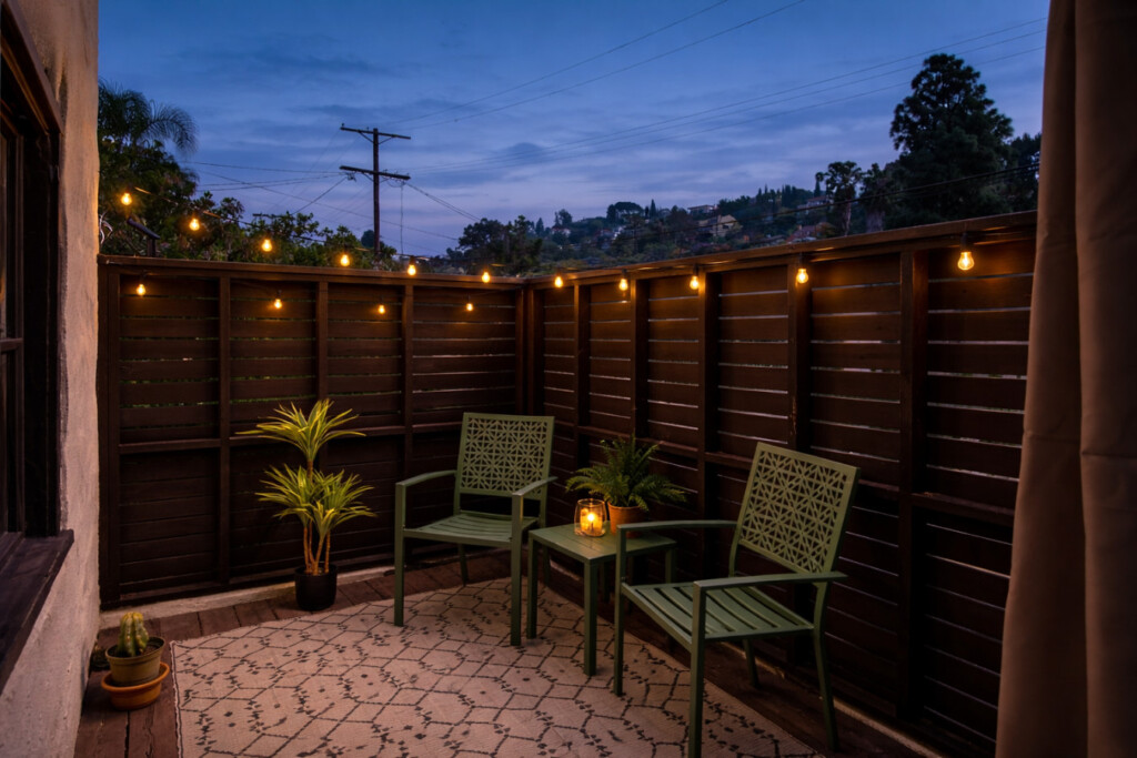 A cozy outdoor corner glowing with string lights, perfect for winding down in the evening. Tucked away and private, it’s a peaceful extension of the home for relaxed nights outside.