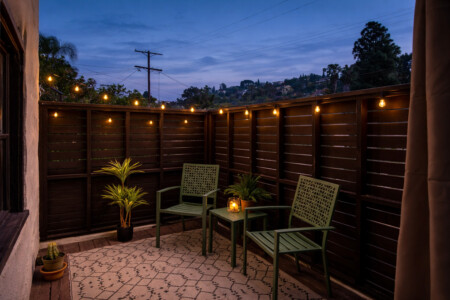 A cozy outdoor corner glowing with string lights, perfect for winding down in the evening. Tucked away and private, it’s a peaceful extension of the home for relaxed nights outside.