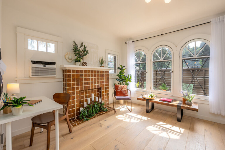 A bright, thoughtfully designed living area with original tilework and a dedicated workspace tucked to the side. With natural light, greenery, and room to focus or unwind, it’s ideal for comfortable longer stays.