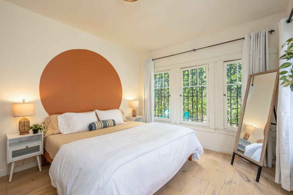 A calm, inviting bedroom with a warm statement wall and soft lighting for restful nights. Designed for comfort and ease, it’s a space you’ll look forward to coming home to each day.