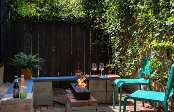 A private brick courtyard with a built-in fire pit, perfect for relaxed evenings under the string lights. Surrounded by greenery, it’s an inviting outdoor space that feels like your own hidden retreat.
