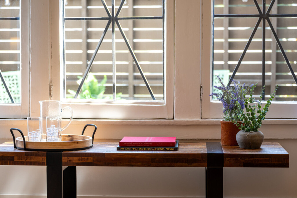 A sunlit corner framed by original arched windows, offering a quiet place to read or unwind. With leafy views and soft light, it’s a peaceful spot to settle into the rhythm of the neighborhood.