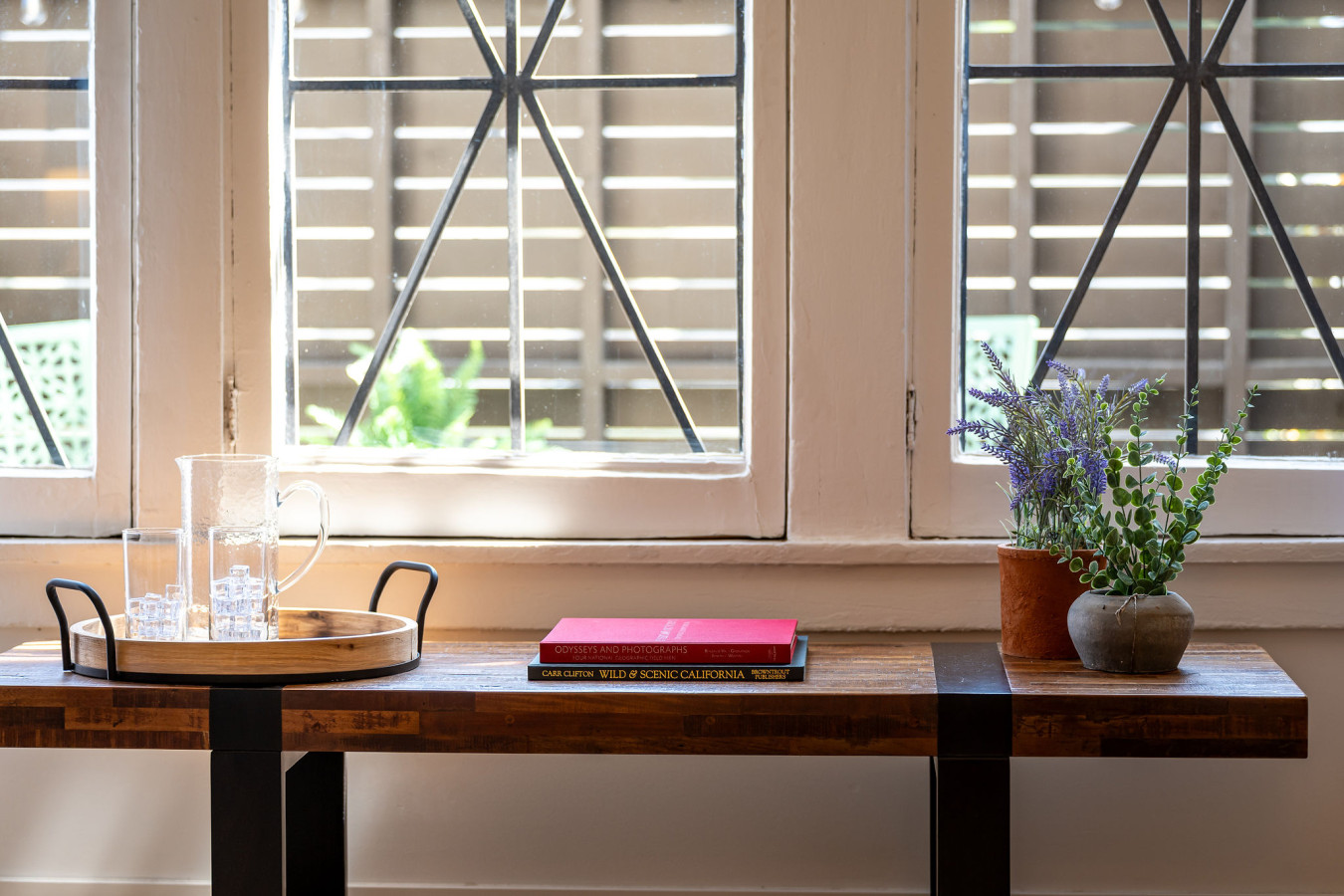 A sunlit corner framed by original arched windows, offering a quiet place to read or unwind. With leafy views and soft light, it’s a peaceful spot to settle into the rhythm of the neighborhood.