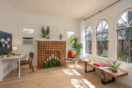 A bright, thoughtfully designed living area with original tilework and a dedicated workspace tucked to the side. With natural light, greenery, and room to focus or unwind, it’s ideal for comfortable longer stays.