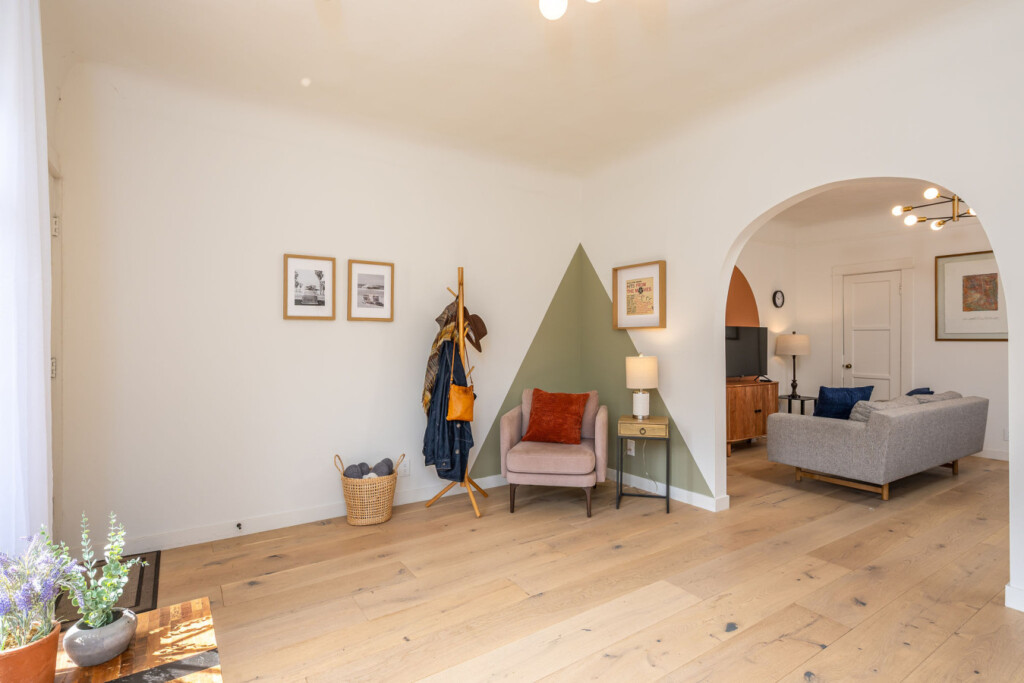 A quiet corner with room to settle in, featuring a cozy reading chair and thoughtful touches throughout. Just beyond the archway, the home opens up, offering both privacy and an easy, connected flow for daily living.